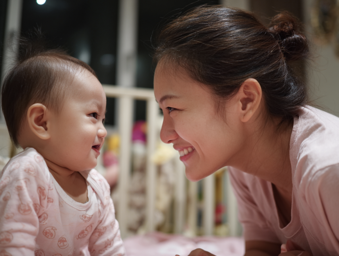 A parent interacting with her infant through play